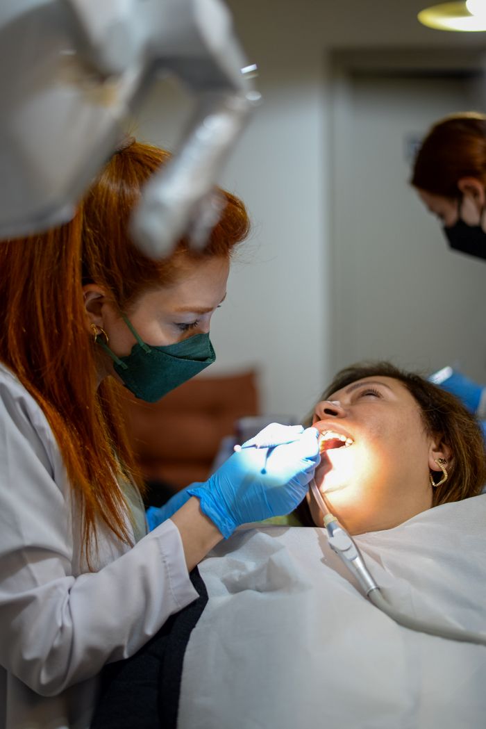 Crafting Captivating Headlines: Your awesome post title goes here A female dentist examining a patient's teeth with precision and care.