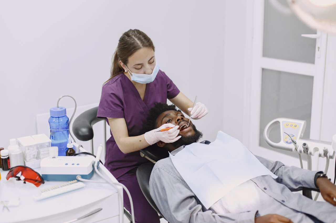 A dentist conducts a dental checkup on a patient in a clinic setting.